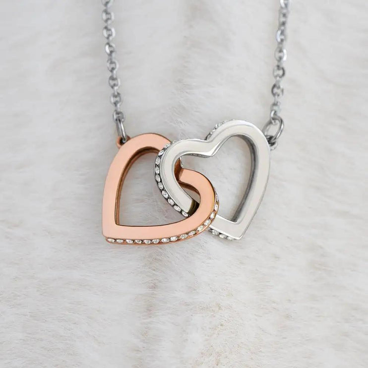 rose gold interlocking hearts necklace on white fleece