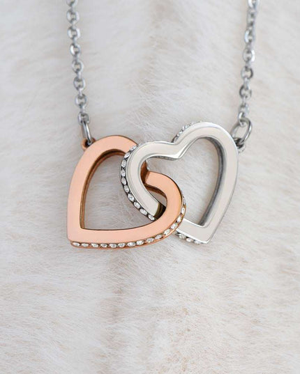 rose gold interlocking hearts necklace on a white felt cloth