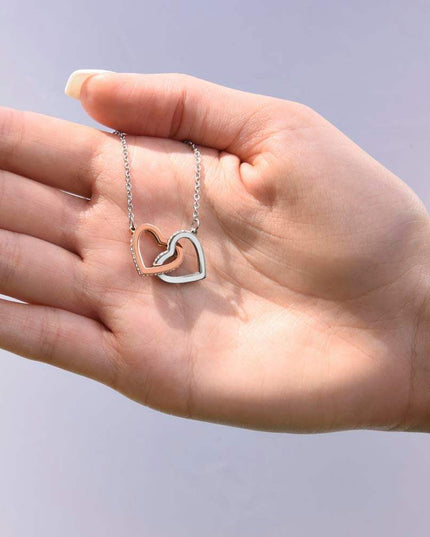 rose gold interlocking hearts necklace on a model's hand