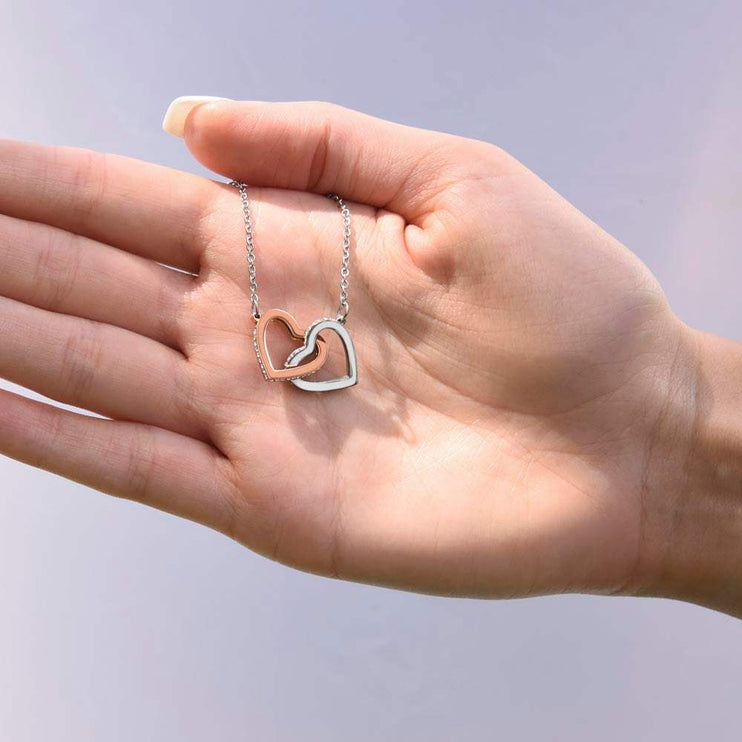 rose gold interlocking hearts necklace on a model's hand