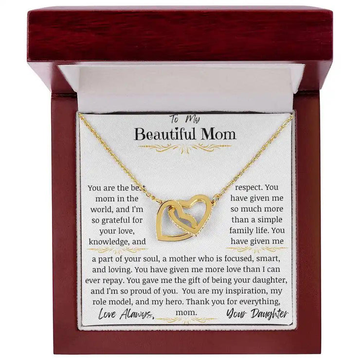 a yellow gold interlocking hearts necklace in a mahogany box