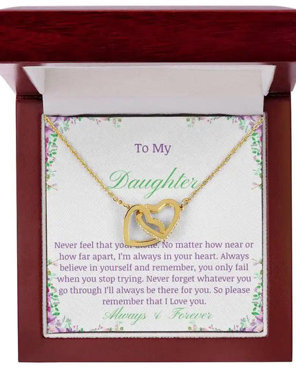 a gold interlocking hearts necklace up close in a mahogany box