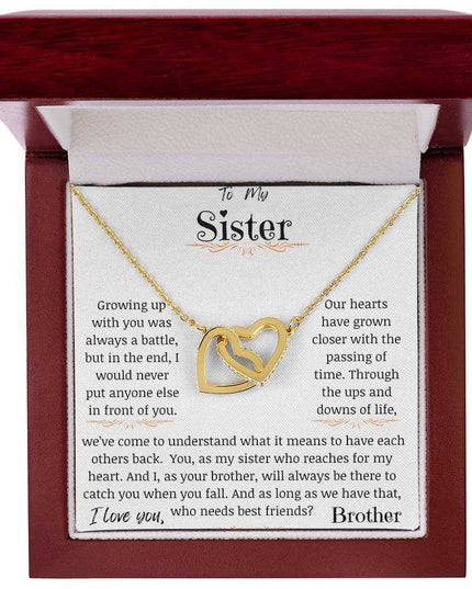 a yellow gold interlocking hearts necklace up close in a mahogany