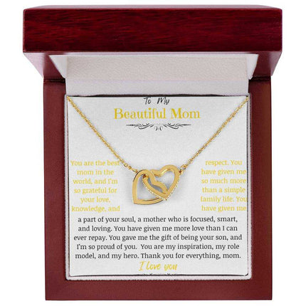 A gold gold interlocking hearts necklace up close in a mahogany box
