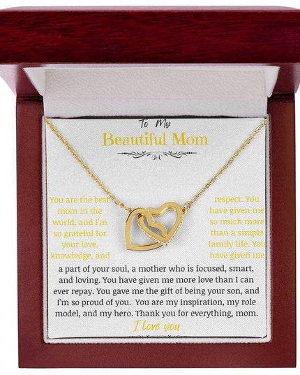A gold gold interlocking hearts necklace up close in a mahogany box