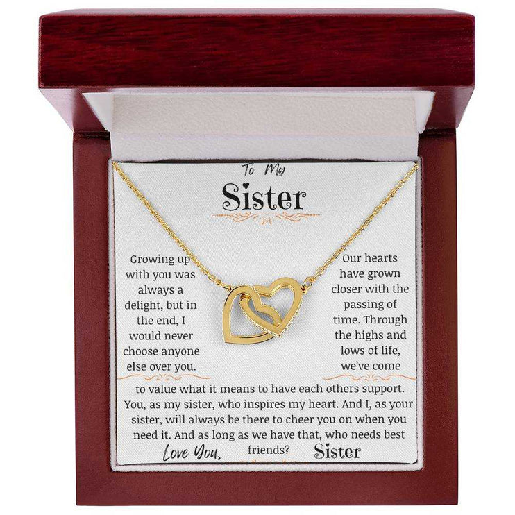 a yellow gold interlocking hearts necklace up close in a mahogany box