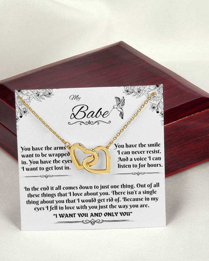 gold interlocking hearts necklace on a message card outside of luxury box
