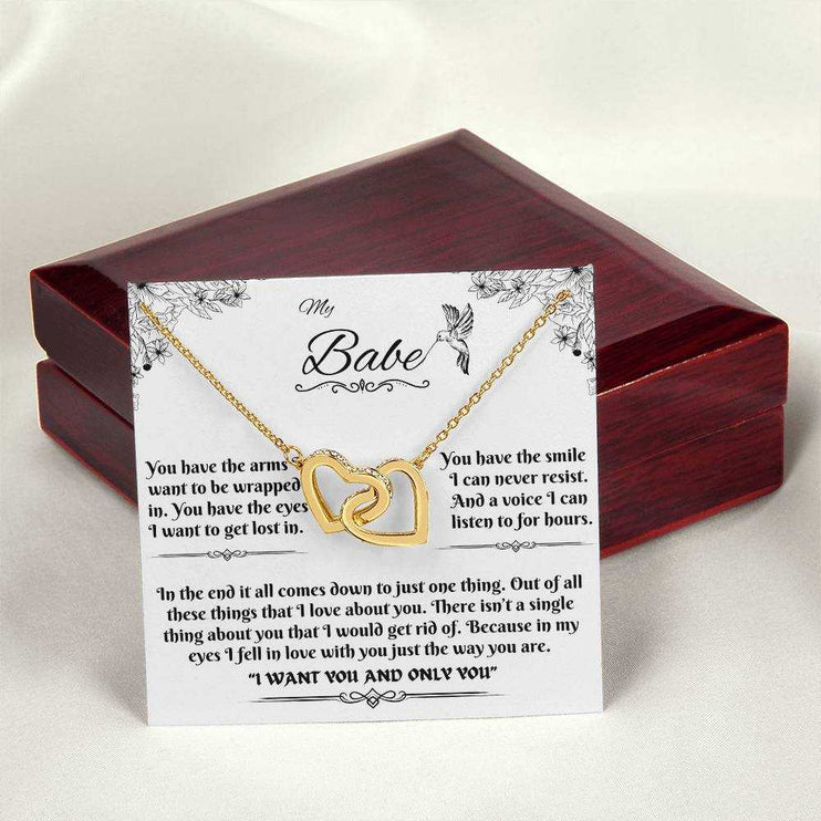 gold interlocking hearts necklace on a message card outside of luxury box