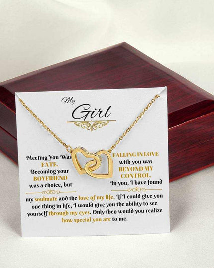 gold interlocking hearts necklace on a message card beside a closed luxury box