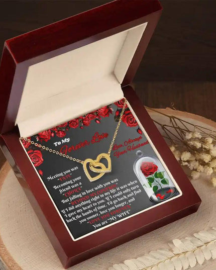 gold interlocking hearts necklace in mahogany box on a stump