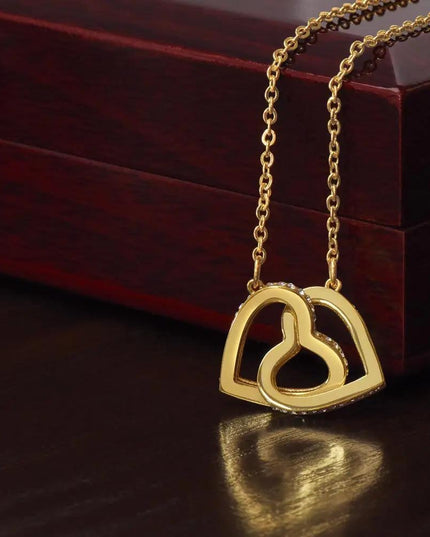 yellow gold interlocking hearts necklace on closed mahogany box
