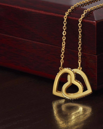 18k interlocking hearts necklace on top of a closed luxury box