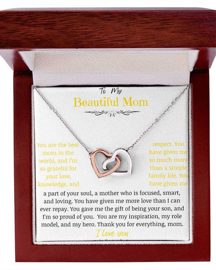 A rose gold interlocking hearts necklace up close in a mahogany box