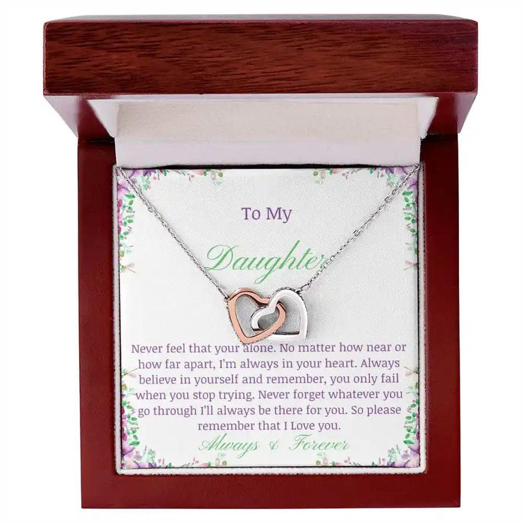 a rose gold interlocking hearts necklace up close in a mahogany box