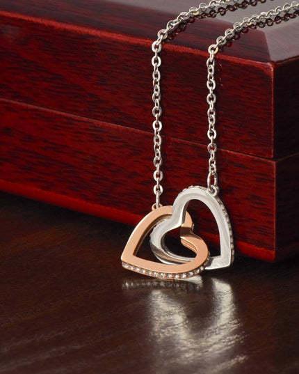 rose gold interlocking hearts necklace on top of a closed luxury box