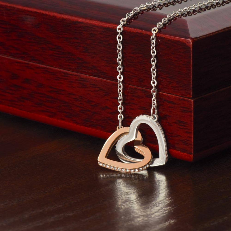 rose gold interlocking hearts necklace on top of a closed luxury box