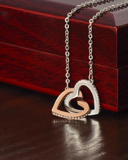 rose gold interlocking hearts necklace on top of mahogany box