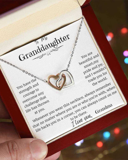 a rose gold interlocking hearts necklace in a mahogany box angled left