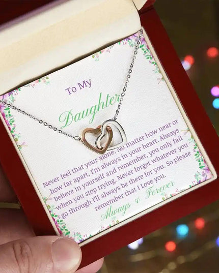 a rose gold interlocking hearts necklace up close in a mahogany box angled to the left