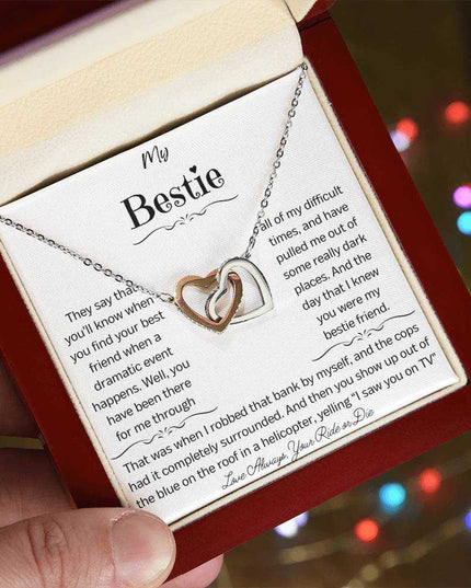a rose gold interlocking hearts necklace in a mahogany box angled left