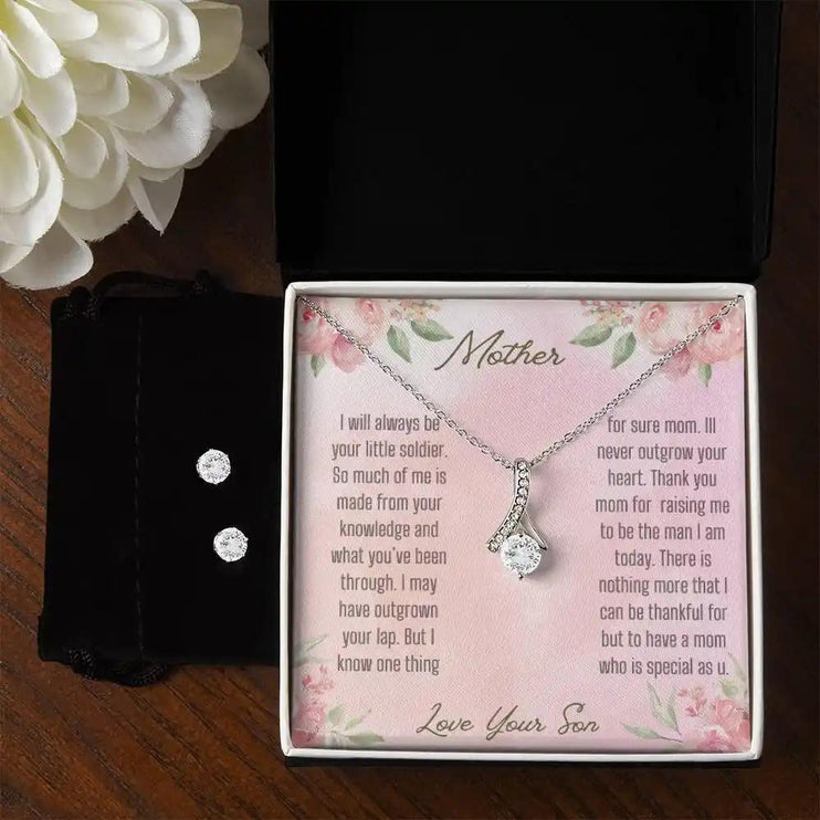 A alluring beauty necklace cubic zirconia earring set in a two-tone box on a table.