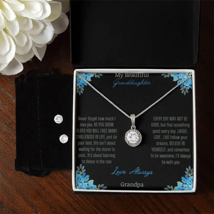 Eternal Hope Necklace Earring Set with a to granddaughter from grandpa greeting card in a two-tone box on a brown table with a white flower and earrings on left side of box