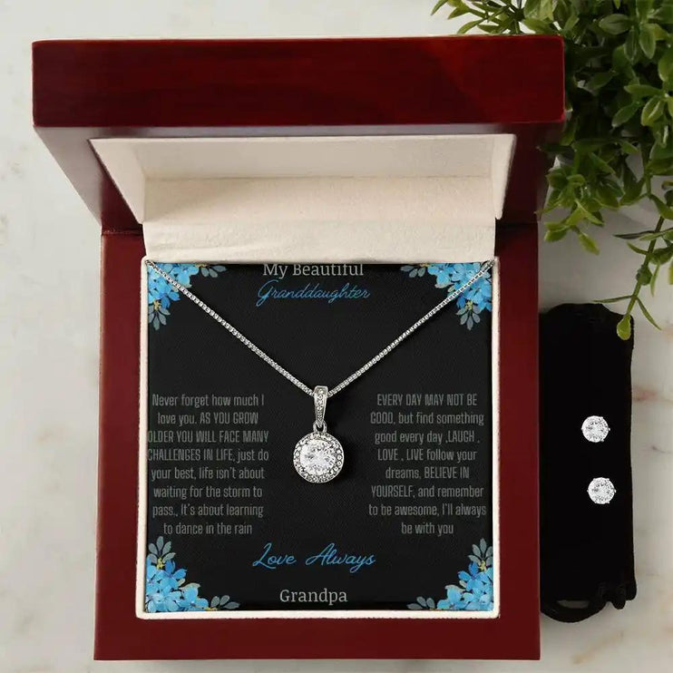 Eternal Hope Necklace Earring Set with a to granddaughter from grandpa greeting card in a mahogany box on a white table with a white flower and earrings on right side of box