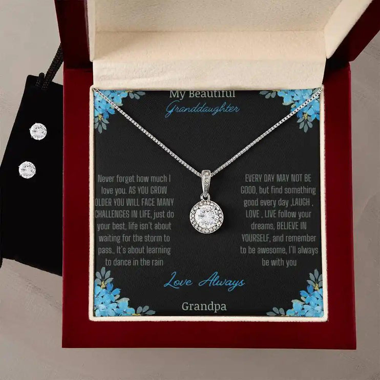 Eternal Hope Necklace Earring Set with a to granddaughter from grandpa greeting card in a mahogany box on a white table with a white flower and earrings on left side of box