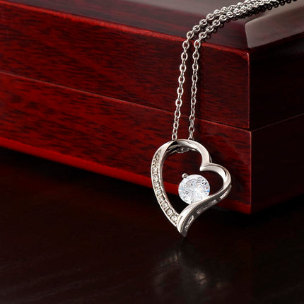 a white gold forever love necklace on a mahogany box