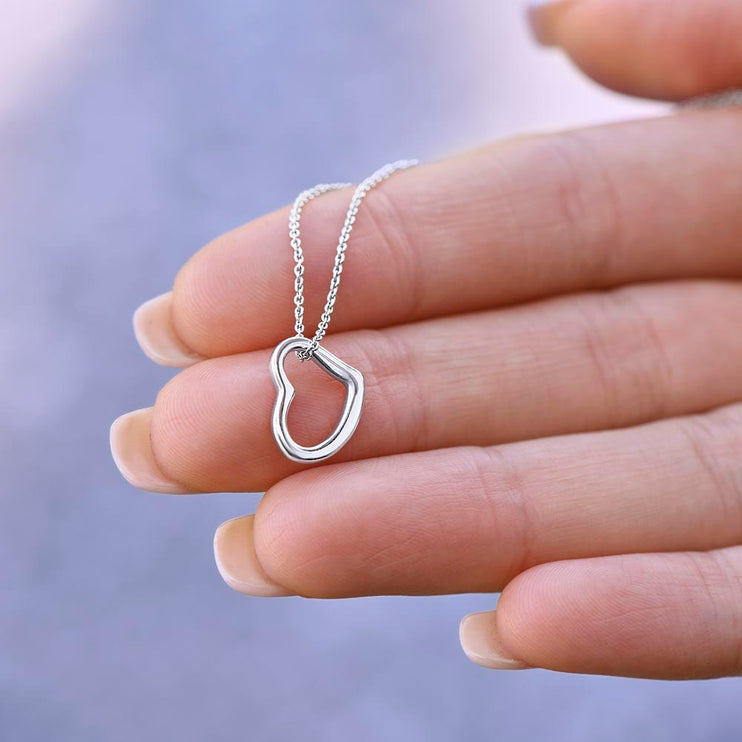 delicate heart necklace on models' hand with white gold variant
