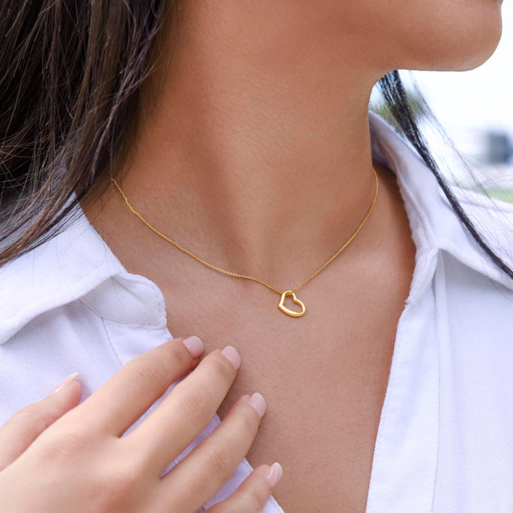 delicate heart necklace on models neck with gold variant