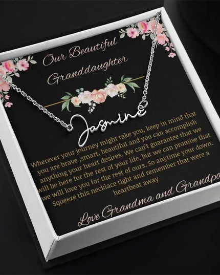 Signature Name Necklace with a polished stainless-steel finish and a to granddaughter from grandma and grandpa greeting card in a two-tone box