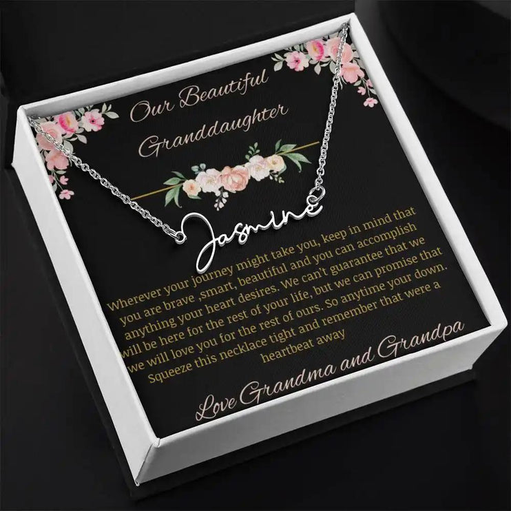 Signature Name Necklace with a polished stainless-steel finish and a to granddaughter from grandma and grandpa greeting card in a two-tone box