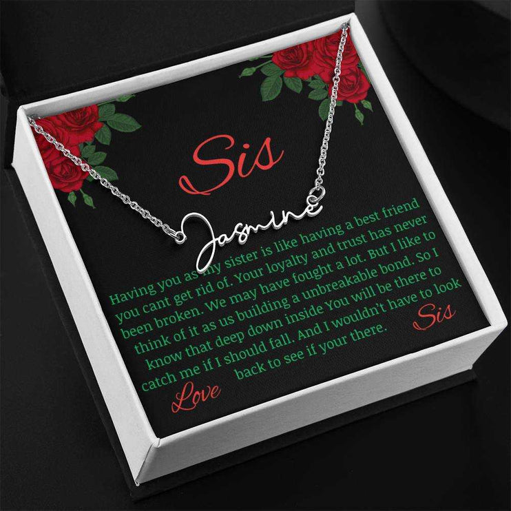Signature Style Name Necklace with a polished stainless-steel variant on a To Sis from Sis greeting card up close in a two-tone box angled to the left.