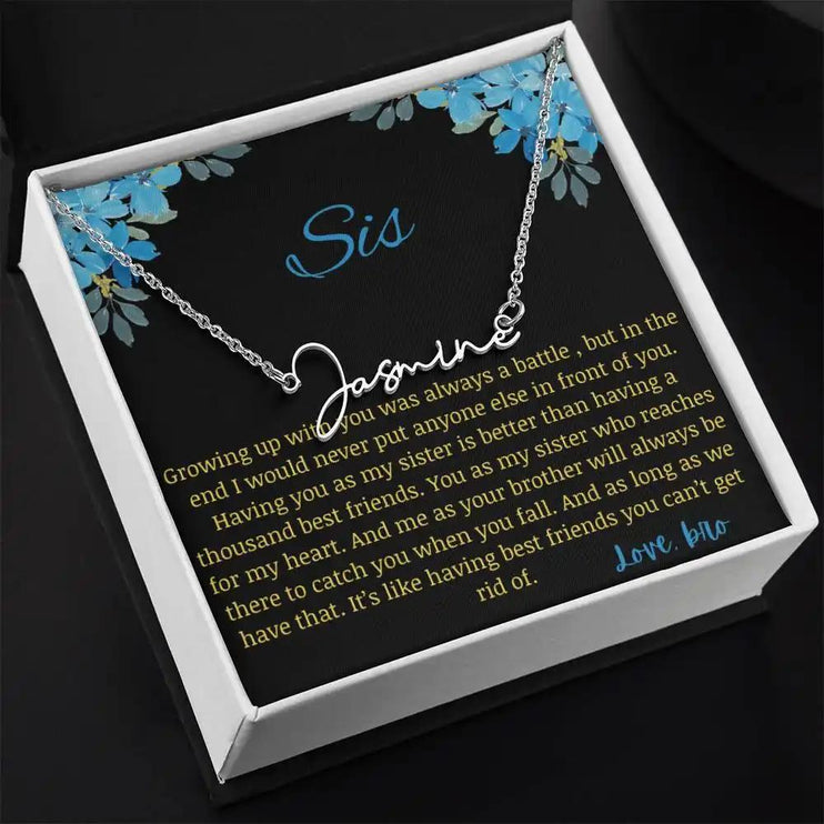 Signature Name Necklace with a polished stainless-steel charm on a to sis from bro greeting card in a two-tone box angled slightly to the right