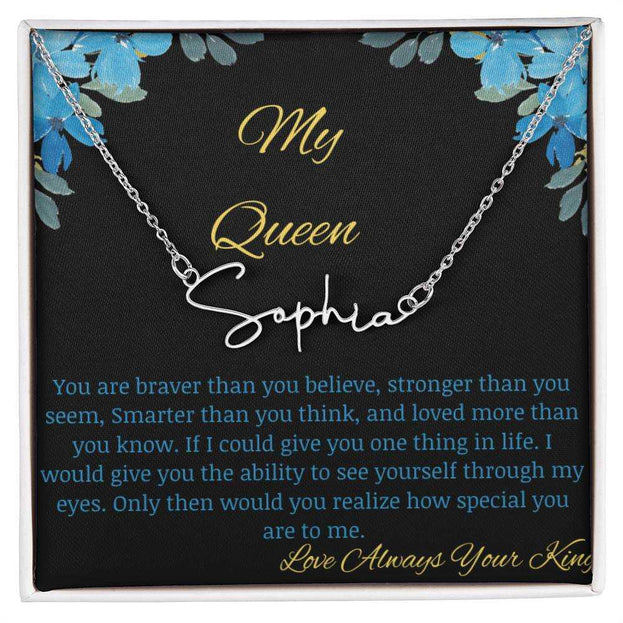 A polished stainless-steel signature name necklace in a two-tone box with a to my queen greeting card.