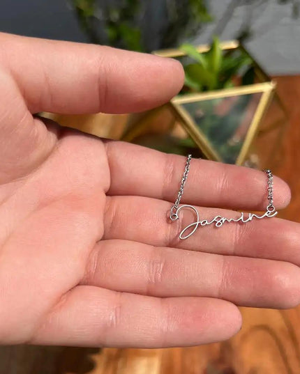 polished-stainless signature style name necklace in model's hand