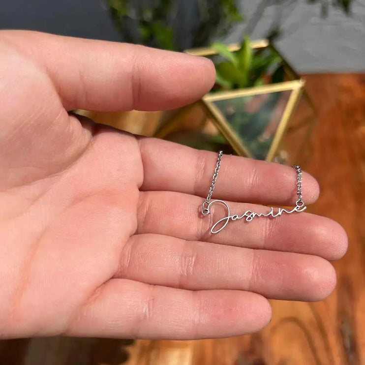 polished-stainless signature style name necklace in model's hand