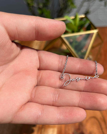 stainless-steel signature name necklace in a model's hand