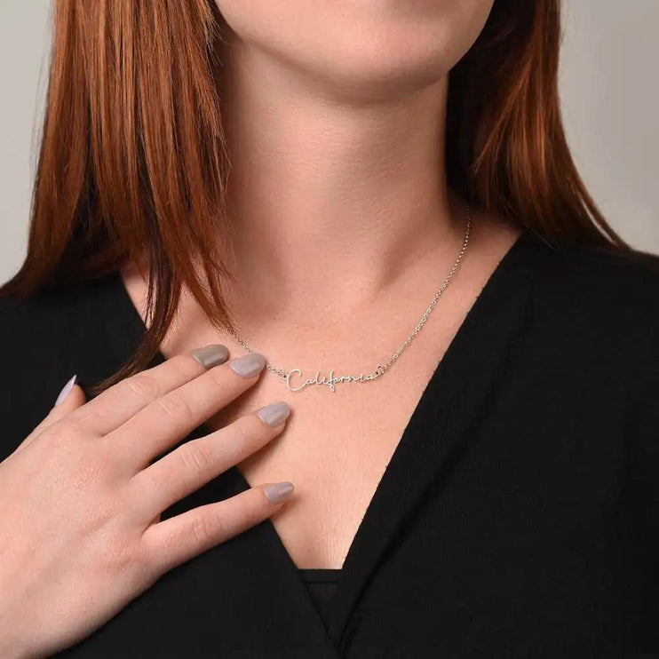 polished steel signature style name necklace on model's neck