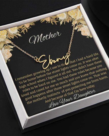 A yellow gold finish signature name necklace up close angled to left.