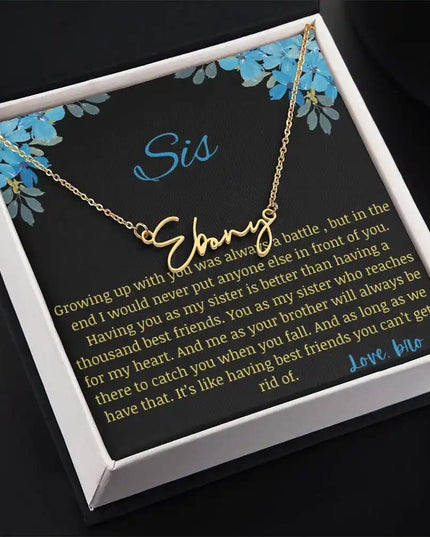 Signature Name Necklace with a yellow gold charm on a to sis from bro greeting card in a two-tone box angled slightly to the right
