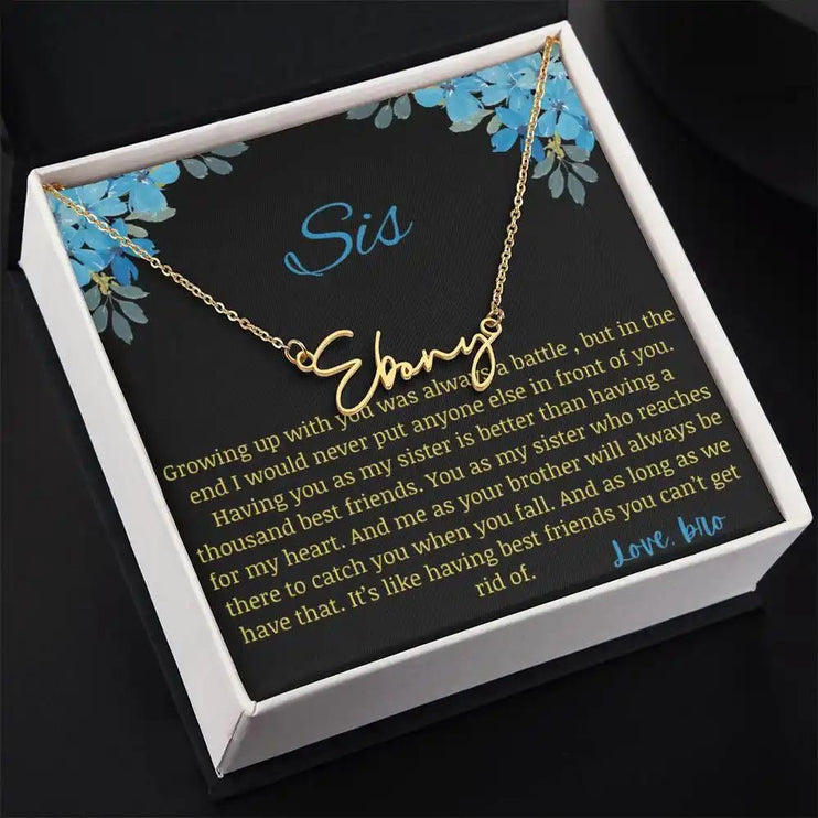 Signature Name Necklace with a yellow gold charm on a to sis from bro greeting card in a two-tone box angled slightly to the right