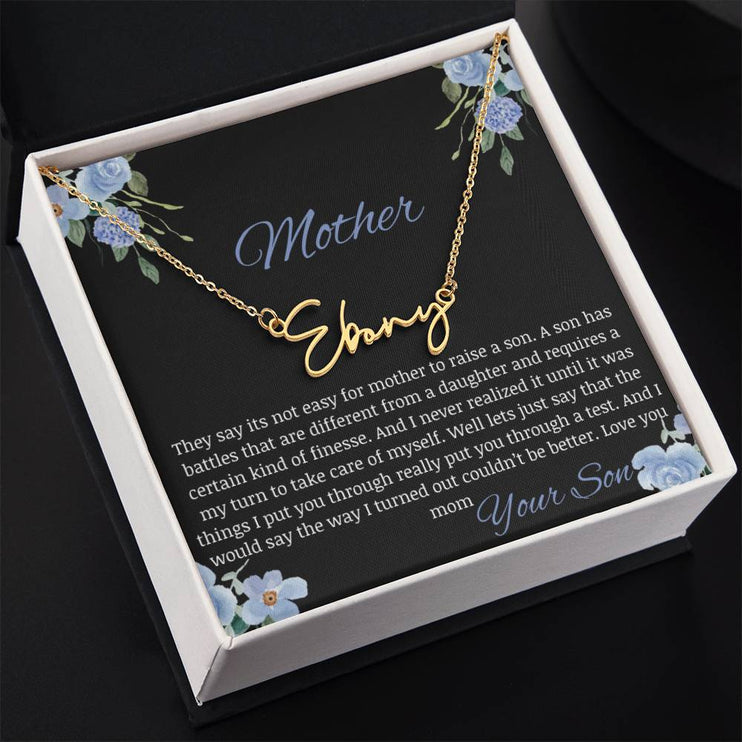 A yellow gold finish signature name necklace in a two-tone box.