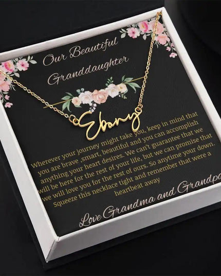 Signature Name Necklace with a yellow gold finish and a to granddaughter from grandma and grandpa greeting card in a two-tone box 