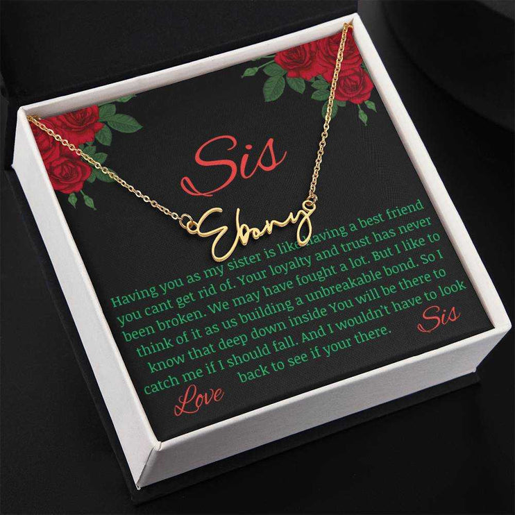 Signature Style Name Necklace with a yellow gold finish variant on a To Sis from Sis greeting inside a two-tone box angled slightly to the left.