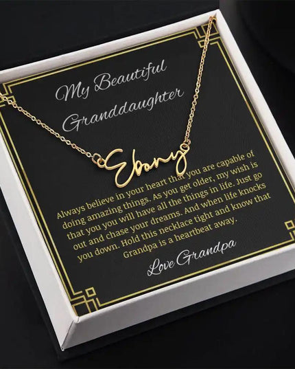 Signature Name Necklace with a yellow gold finish on a to granddaughter from grandpa greeting card in a two-tone box angled to the right