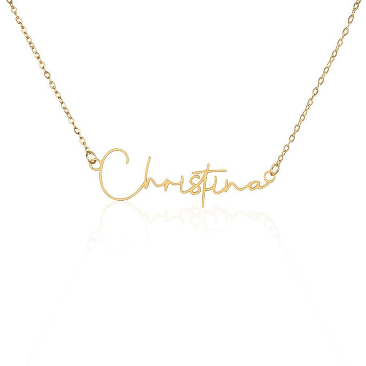 yellow gold signature name necklace on a white back drop