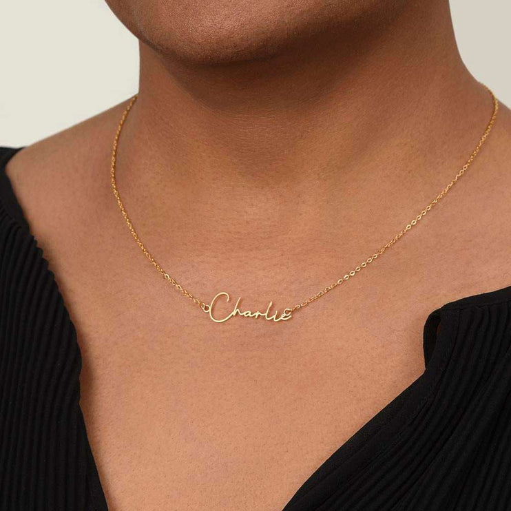 yellow gold signature name necklace on a model's neck