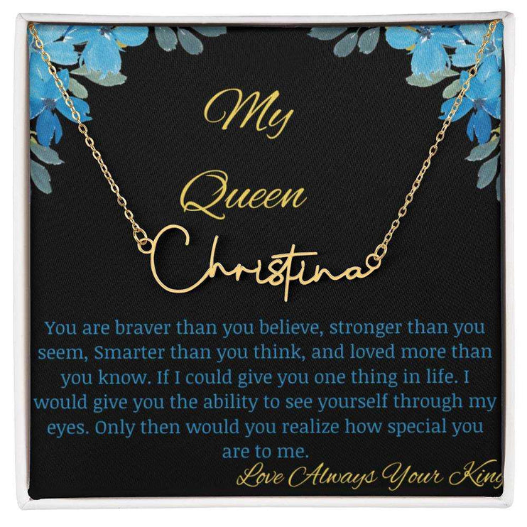 A yellow gold signature name necklace in a two-tone box with a to my queen greeting card.